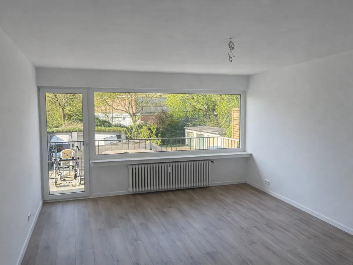Nachher-Ansicht eines renovierten Wohnraums mit Fenster und Laminatboden