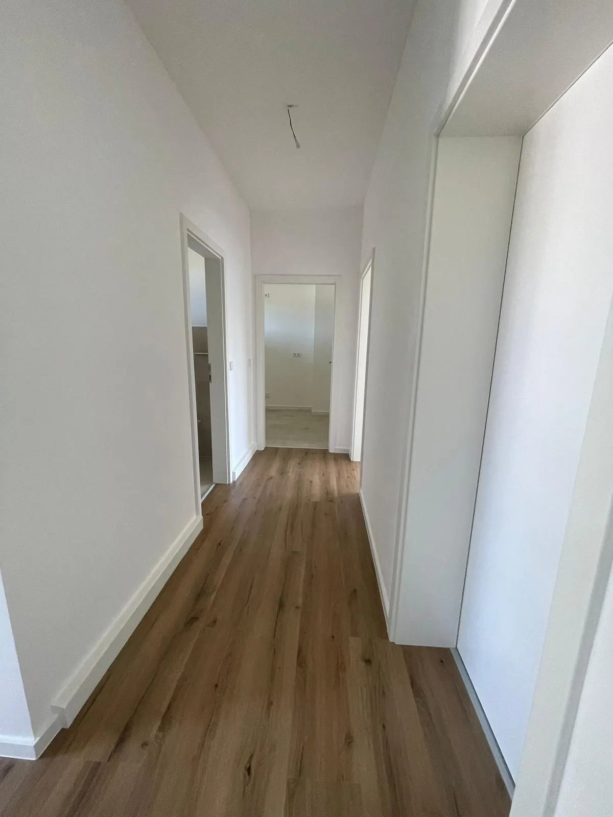 Echtes Referenzfoto eines renovierten Flurs mit neuem Laminatboden